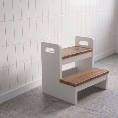 A two-step wooden step stool with a white frame and cutout handles, set in a tiled room with white wall tiles and gray floor tiles.